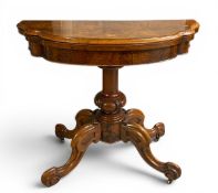 A mid 19th century burr walnut card table with foldover top and swivel action above a carved