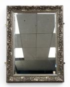 A contemporary wall mirror with rectangular bevelled plate in a silvered Art Nouveau style scrolling