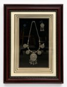 A vintage tribal style white metal necklace and earring set in a glazed box-frame. H.54 W.41cm