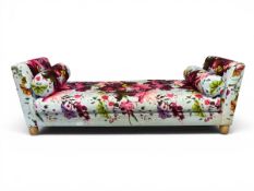 A contemporary Recamier daybed with vibrant butterfly and flower print calico upholstery raised on