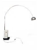 A contemporary Italian Arco floor lamp with an arched stainless steel arm and shade raised on a