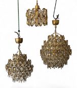 A set of three brass and cut glass Palwa style chandeliers. H.66 W.40cm largest
