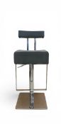 A contemporary bar stool having a grey velour upholstered back and seat with chrome stem and