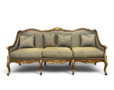 A contemporary Louis XV style three seater walnut sofa having a shaped back with a carved and gilt