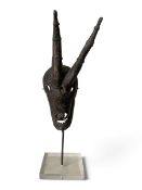 A horned bronze suah dua mask on stand, possibly Mambila, Cameroon. H.34cm with stand.