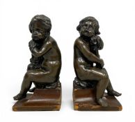 A pair of bronze figural cherub bookends in the French 19th century style raised on shaped plinth