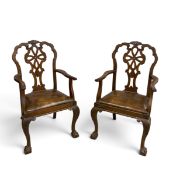 A pair of early Georgian style open armchairs with distressed leather drop in seats. H.106 x W.60
