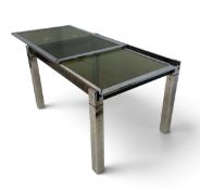 A C.1970 dining table with extending chromed metal base with smoked glass top. Stamped ARCH LA METAL