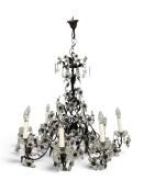 A contemporary eight branch metal framed chandelier in the antique style of scrolling naturalistic