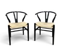 A pair of ebonised wishbone armchairs based on the model CH24 Hans Wegner with woven paper cord