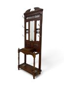 An Edwardian hallstand, mahogany and oak with turned spindles and brass coat hooks, fitted with drip