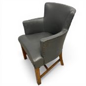 A pair of vintage tub chairs each having a curved back and arms over a cushioned seat upholstered in