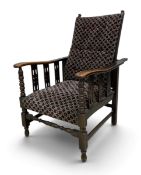 A late 19th century oak reclining armchair with adjustable action, turned spindles and legs and