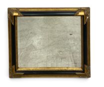 A 19th century style wall mirror, ebonised frame with gilt foliate decoration. H.67 x W.76cm.