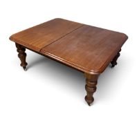 A 19th century mahogany extending dining table with turned legs on brass casters with three leaves