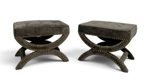 A pair of contemporary arched x-frame foot stools in deep buttoned upholstery with pipping and
