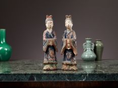 A PAIR OF CHINESE POLYCHROME DECORATED FIGURES OF COURT LADIES, PROBABLY MING DYNASTY
