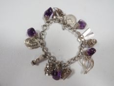 A silver and amethyst charm bracelet approx weight 51g