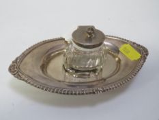 A hallmarked silver inkwell on a small hallmarked silver stand