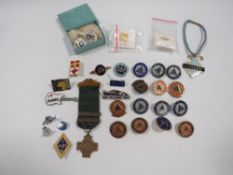 A small box of assorted pin badges etc