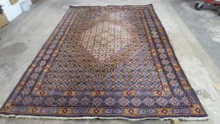 A multi coloured middle eastern woollen rug, blue, red, green and cream size 3.2m x 2.12m