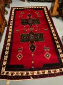 An Eastern woollen rug mainly with a red ground 268 x 153 cm