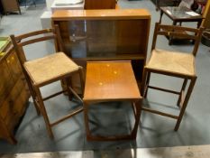A retro bookcase together with two wicker seat stools and a teak table. (4)