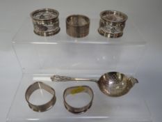 A hallmarked silver tea strainer together with fiver silver napkin rings approx combined weight 109g