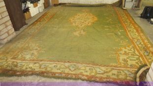 A very large woollen rug in green, cream and red colourway, with fringe, approx. 3.4 m x 5.3 m