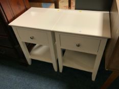 A pair of white show home bedside cabinets