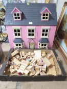 A modern reproduction child's dolls house with a tray of accessories
