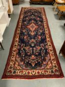 A large Eastern woollen rug/runner - mainly blue and red ground 340 x 119 cm