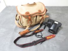A Nikon F-501 camera and accessories in a vintage Billingham camera bag