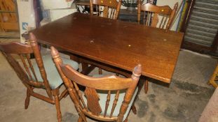 A modern oak finished dining table and four chairs