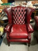 A oxblood red leather wingback armchair