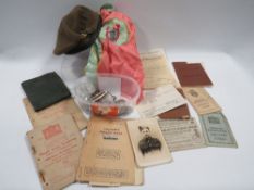 A basket of assorted ephemera to include a Welsh Regiment beret, character certificate etc