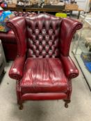 A oxblood red leather wingback armchair