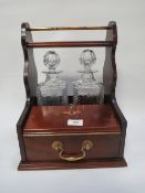 A two bottle tantalus and twin glass set with key