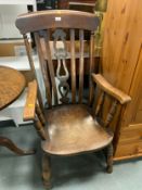 An antique elm kitchen armchair