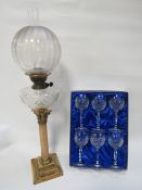 A tall column oil lamp with etched shade together with a set of six Schott crystal cut glasses