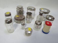A collection of assorted toilet jars, bottles etc to include American and English silver topped