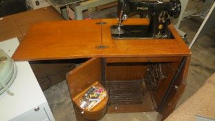 A vintage singer sewing machine in wooden cabinet - House clearance