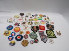 A tin of vintage badges, cloth badges etc