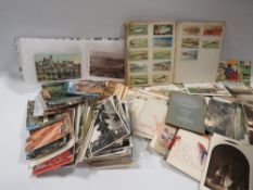 A tray of vintage postcards and stamps etc