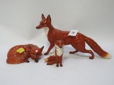 Three Beswick foxes seating, large running A/F and curled up