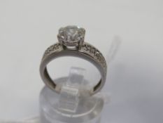 A 9ct white gold ring set with a large CZ stone and small cluster CZ shoulders, total weight 2.3g