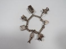 A silver charm bracelet adorned with 6 charms approx weight 52g