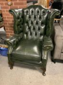A green leather wingback button back armchair