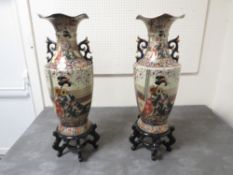 A pair of large Oriental style vases on stands