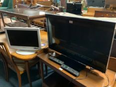 A Panasonic 31” flatscreen television with an older Panasonic tv - remotes